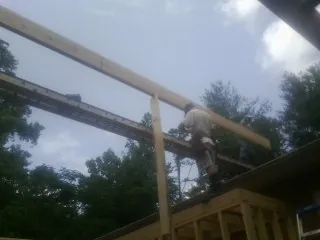 Carpenter setting a ridge beam over a new addition frame — Ice Dam Removal by Roofing Brothers in Fenwick Island